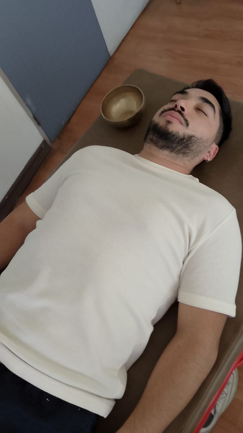 Persona recostada con los ojos cerrados sobre el mat