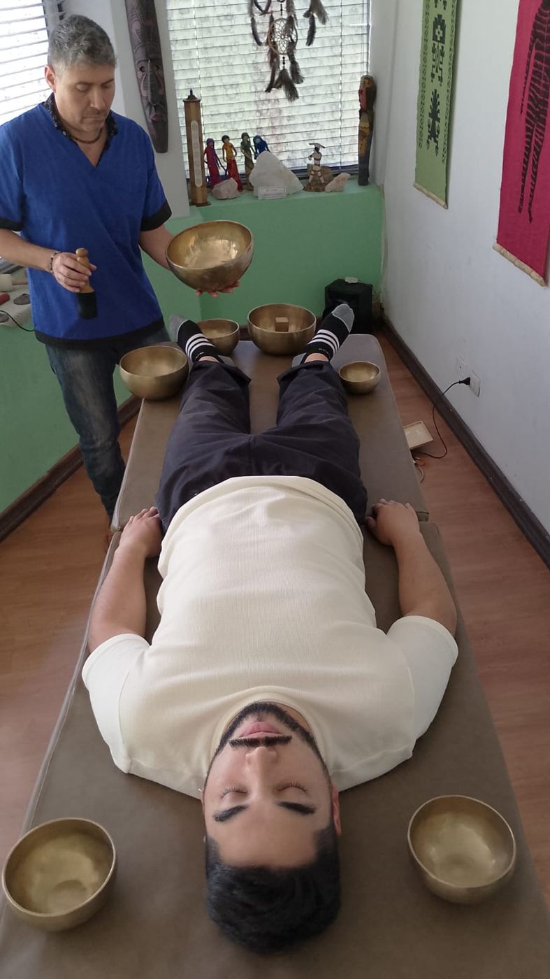 El terapeuta toca cuencos alrededor de la persona